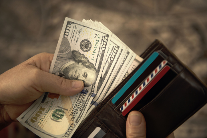 Man holding a wallet with cash.